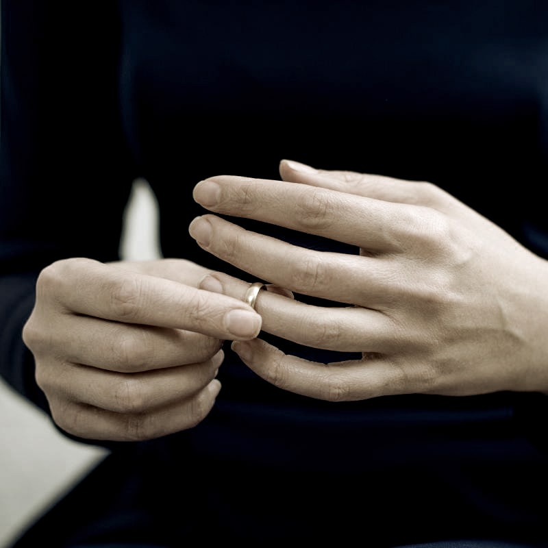 a woman removing her wedding ring